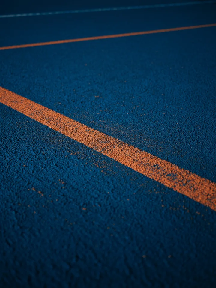 Piso de pista de atletismo com raia demarcada em diagonal